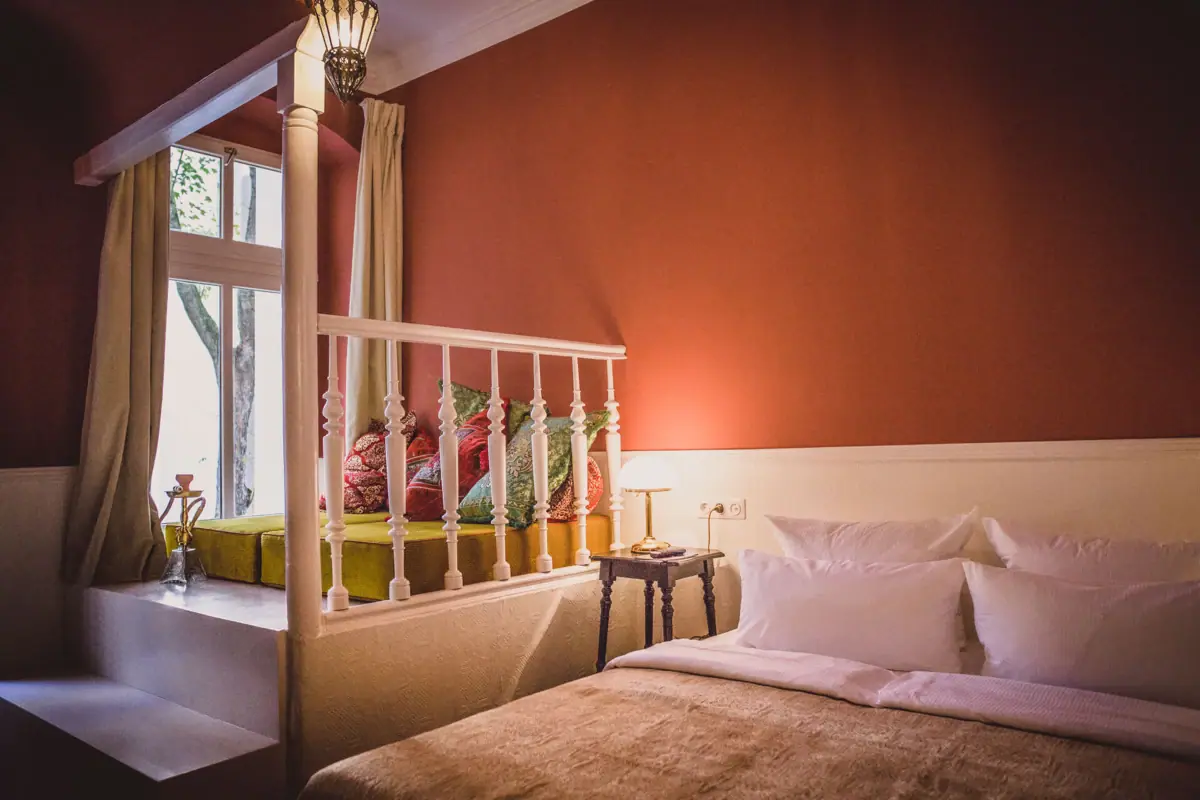 A bed with pillows and a lamp in a room.