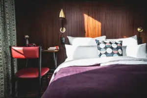 A bed with pillows and a desk in a room.