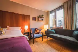 The L-Studio hotel room at the HENRI Hotel Düsseldorf with a bed and a sofa.