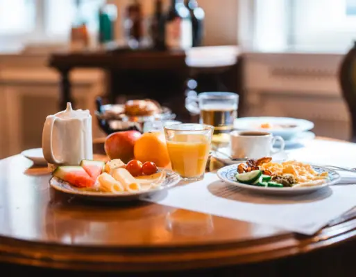 Wooden table set with breakfast plates and drinks