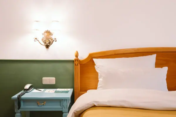 A bed with bedside table and telephone.