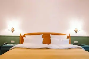 A hotel room at the HENRI Hotel Garmisch-Partenkirchen with a bed in front of a green and white wall.
