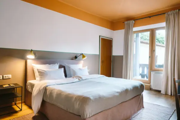 A bed in a hotel room at the HENRI Hotel in Garmisch-Partenkirchen, featuring a stylish interior.
