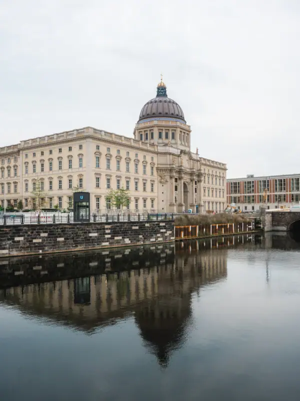 A building with a dome on the roof and a bridge over the water.
