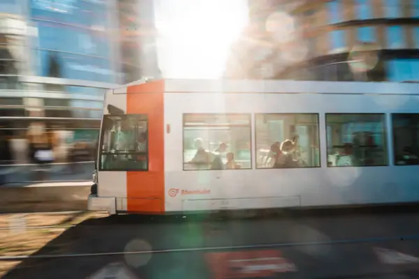 A white and orange bus on a road.