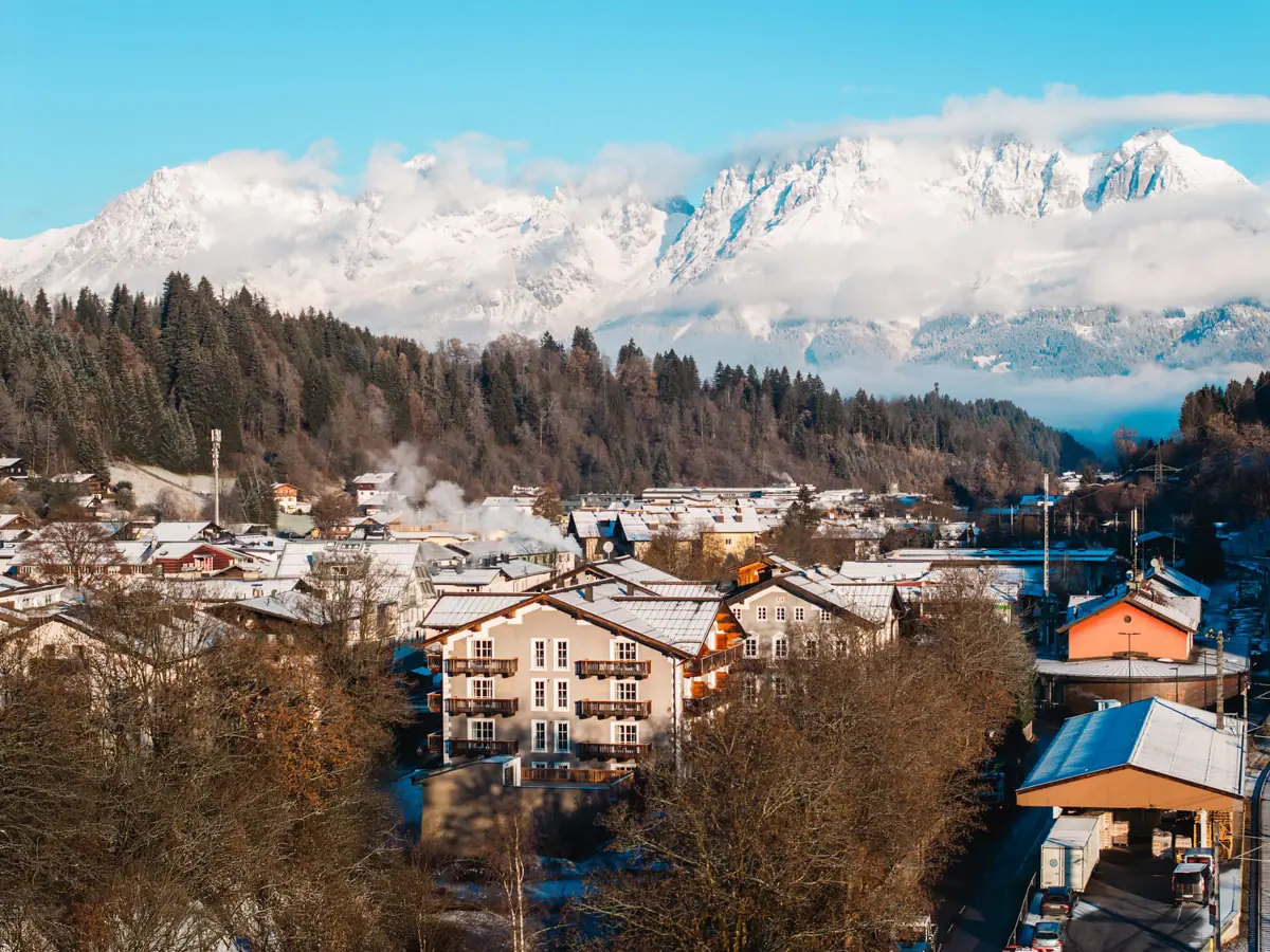 A mountain village with snow-capped mountains in the background.