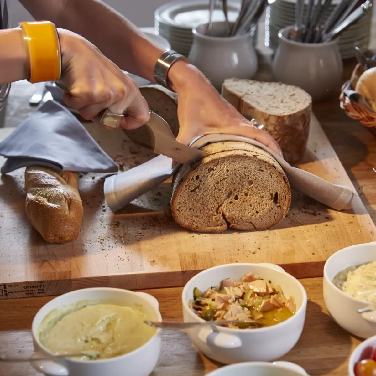 A person is cutting a loaf of bread.