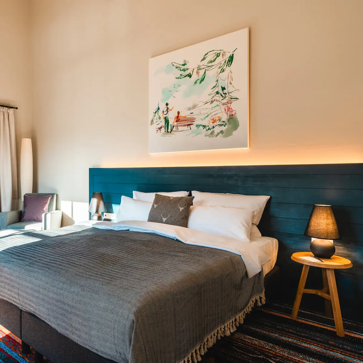 Bed in a stylishly furnished bedroom with pillows and bed linen.