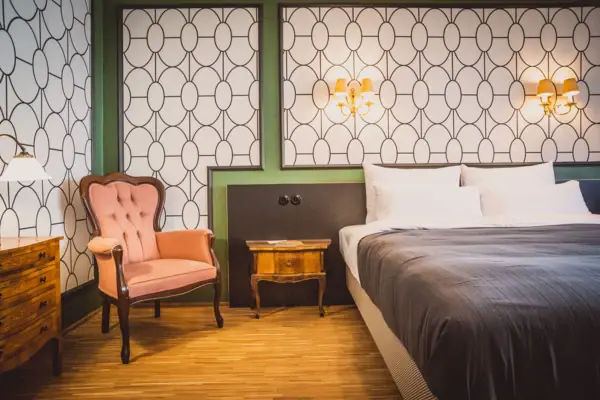 A bedroom with a bed and a chair.