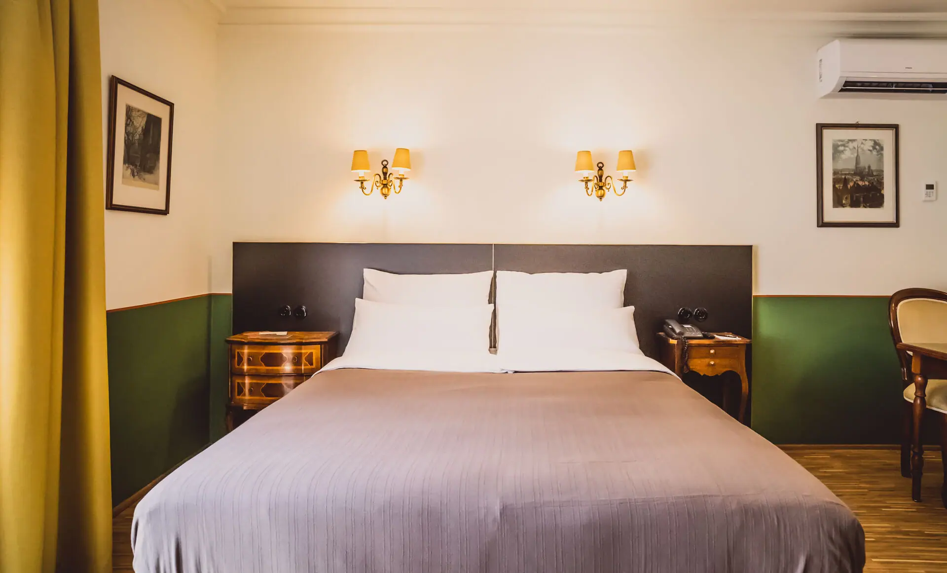 A bed with two wall-mounted lamps in a hotel room.