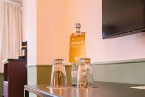 A bottle and glasses on a table.