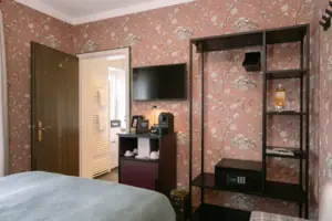 A room with a television and a shelf.