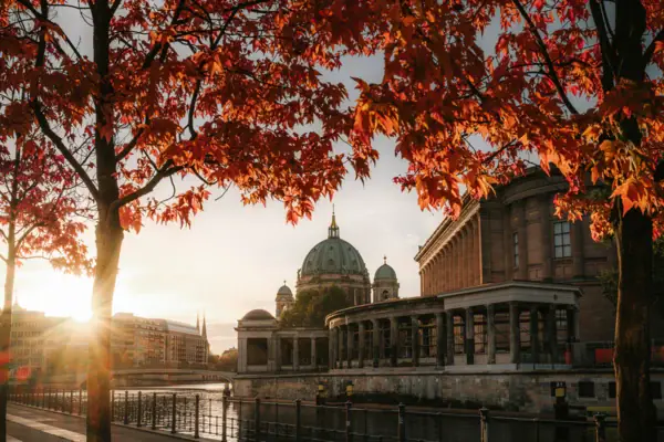 Berlin's Museum Island, framed by trees with vibrant red and orange leaves