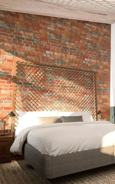 Interior view of a hotel room with a bed, table and chairs.