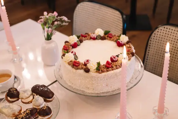 A cake with a pink candle on a plate.