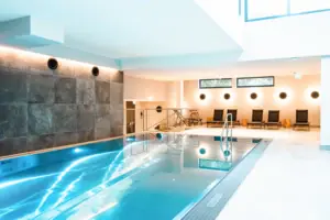 Indoor pool with steps and chairs.