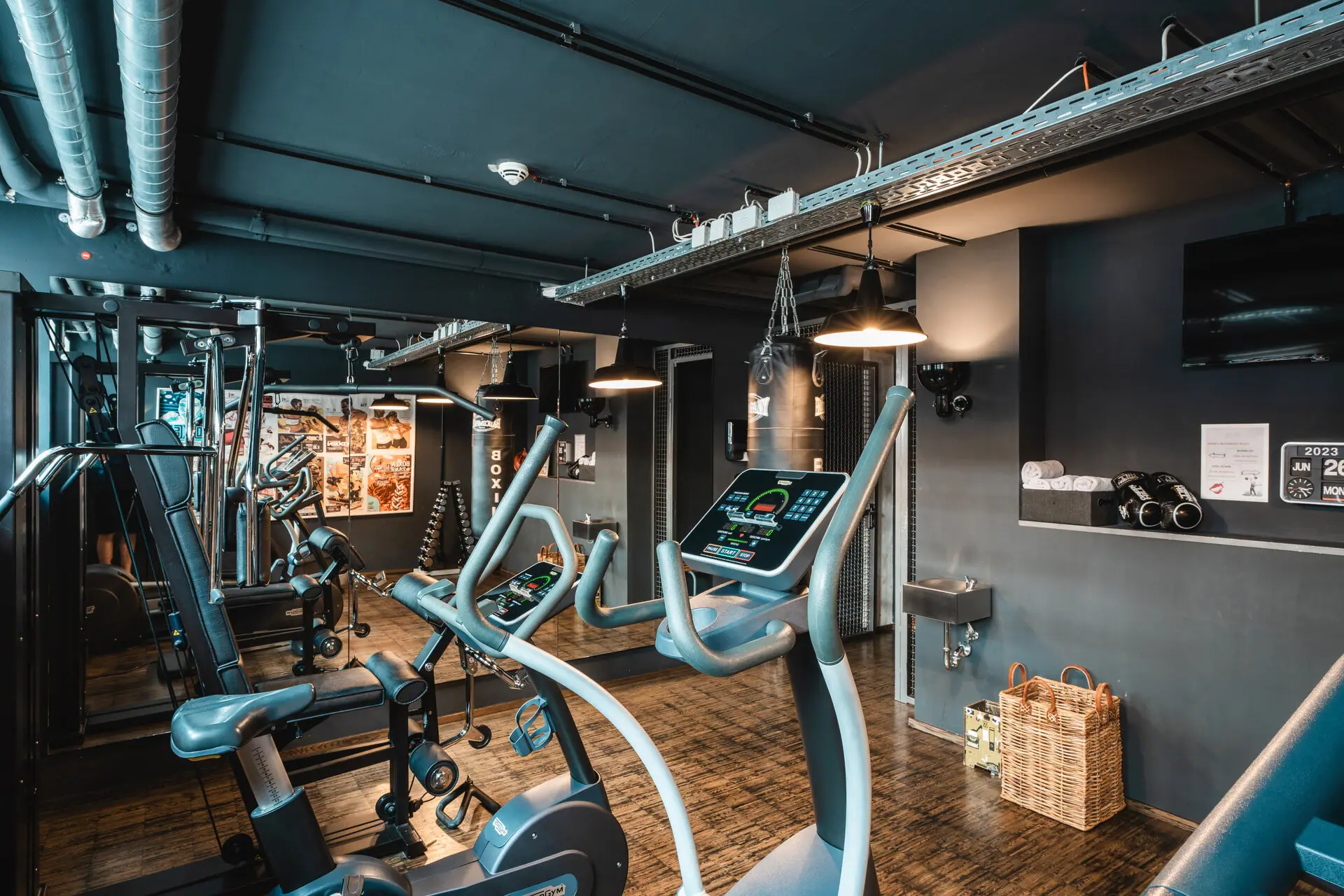 Fitness centre at the HENRI Hotel Hamburg A room with fitness equipment and a wooden floor.