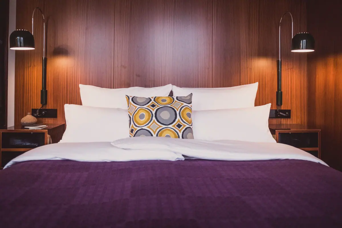 A bed with pillows and a lamp.