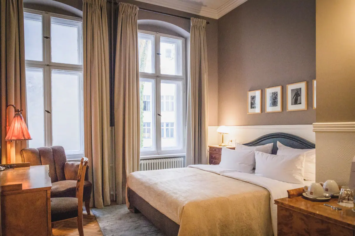 A bedroom with a bed and chairs.