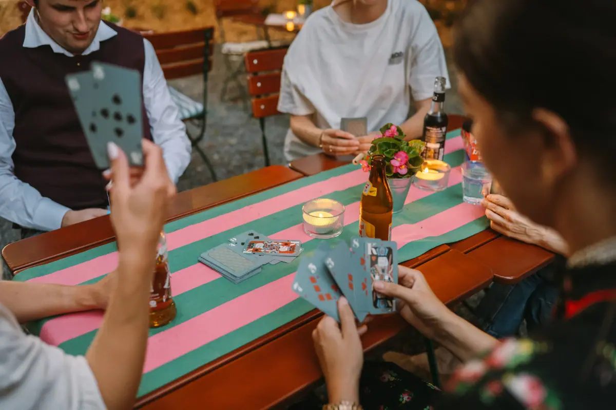 A group of people are sitting at a table playing cards.