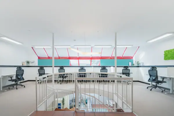 Impuls Raum Garmisch-Partenkirchen A white room with a staircase and chairs.