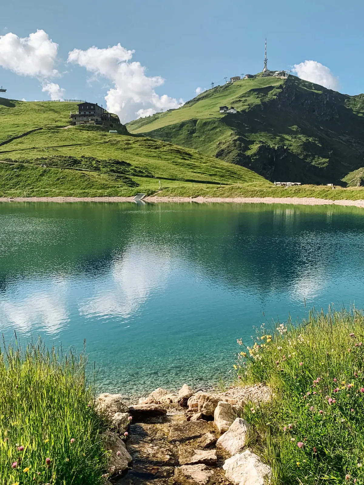 Body of water with hill and building in the background.