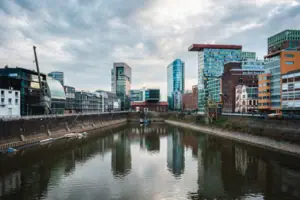 River with buildings in the background and cloudy sky.