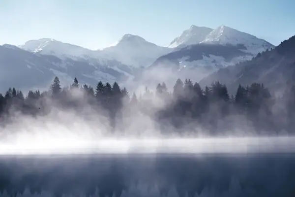Kitzbühel Schwarzsee A misty lake with mountains in the background