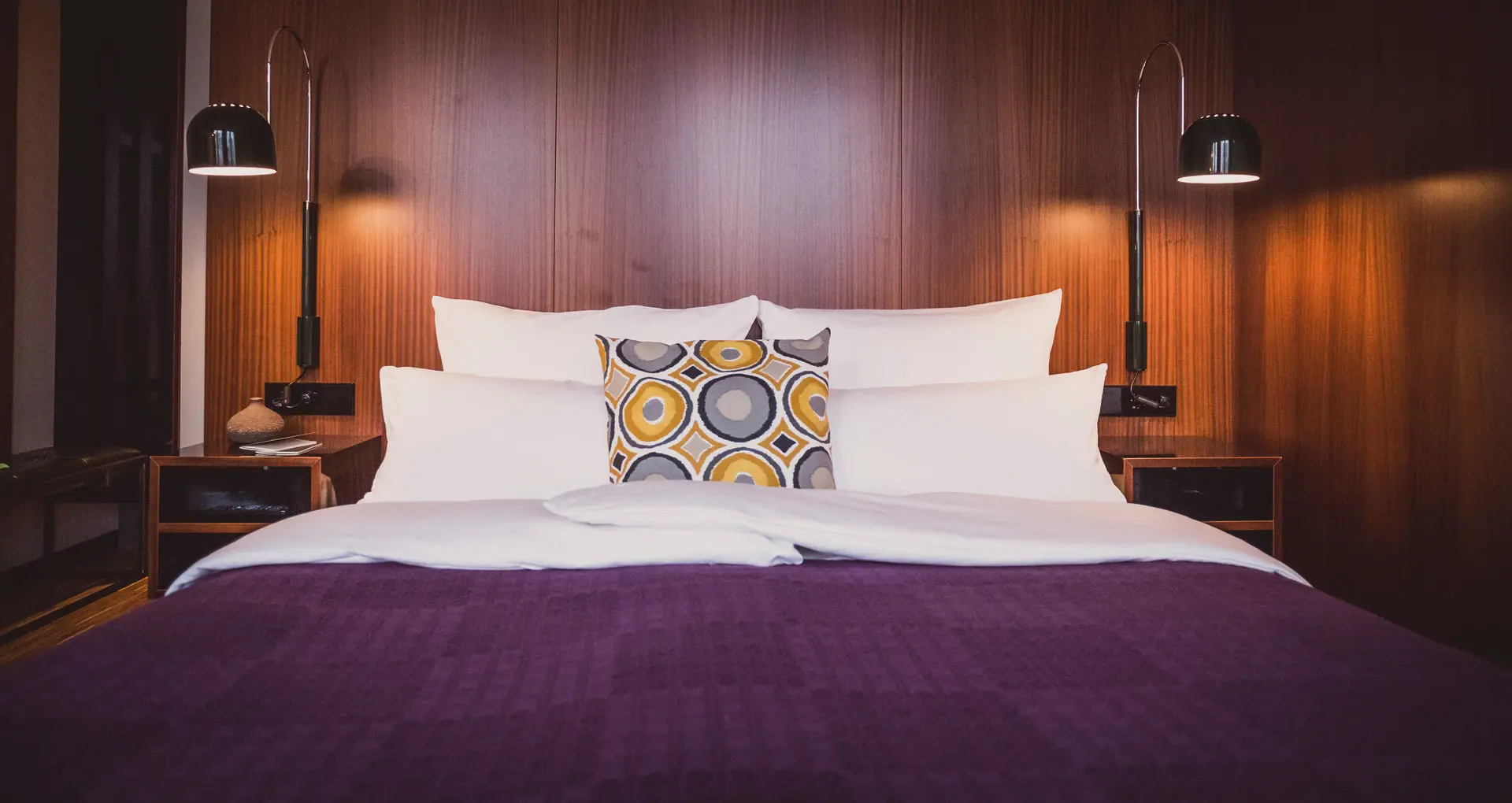A bed with pillows and a lamp.