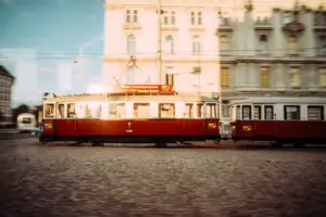 Red and white trolley cars on a street.