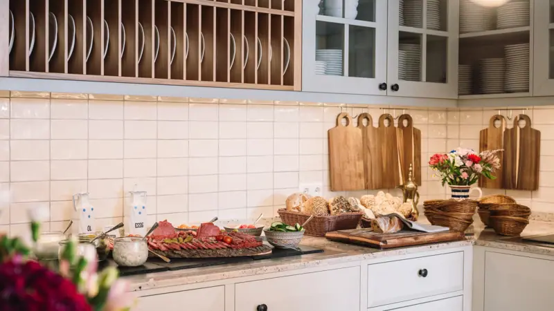 A kitchen with white cupboards and white worktops.