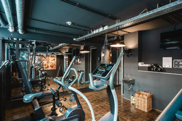 Fitness centre at the HENRI Hotel Hamburg A room with fitness equipment and a wooden floor.