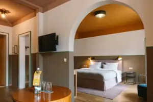 A hotel room at the HENRI Hotel in Garmisch-Partenkirchen, featuring a bed and a television.