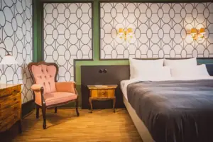 A bedroom with a bed and a chair.