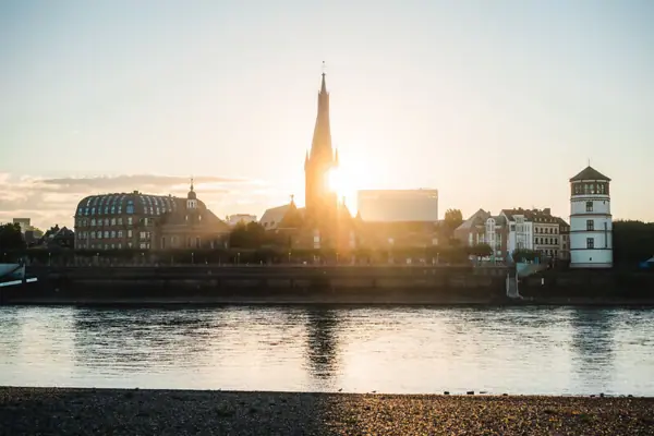 Water surface with buildings and a tower in the background.