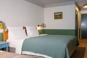 A bed with a green bedspread and a lamp in the bedroom.