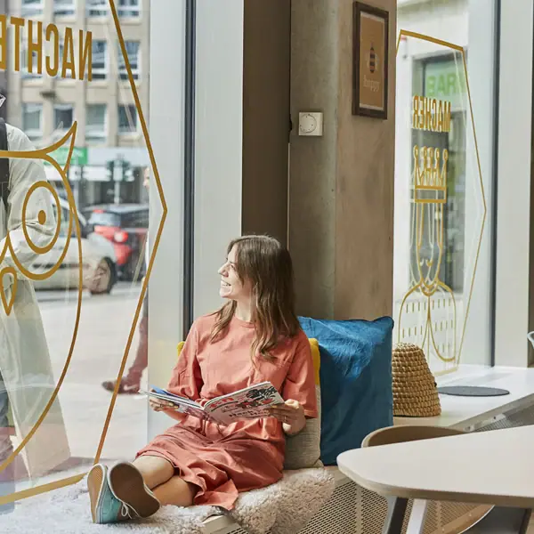 A woman sits on a windowsill.