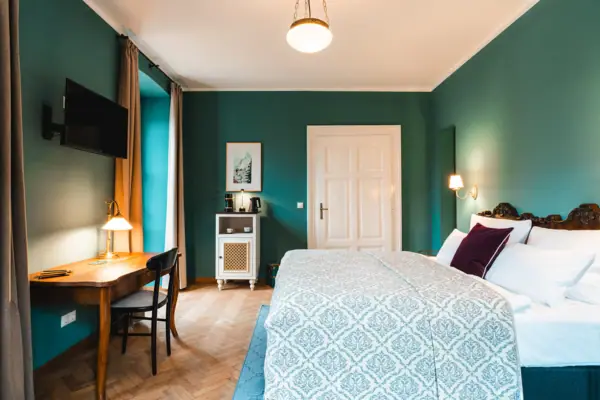 A bedroom with a desk and a bed.