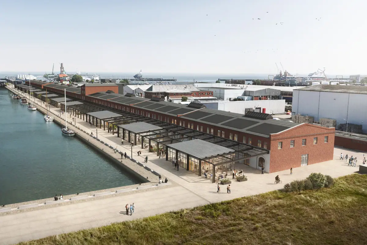 A dock with a row of buildings beside a body of water.