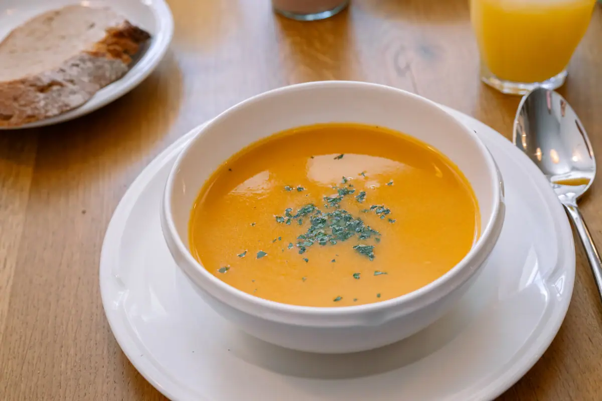 A bowl of soup on a plate.