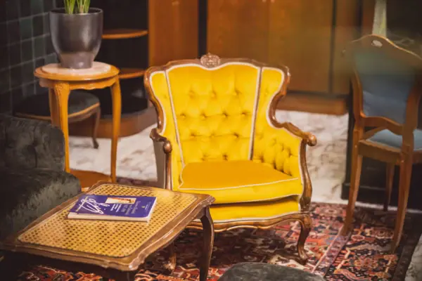 Lounge at the HENRI Hotel Vienna A yellow chair and table in a room.