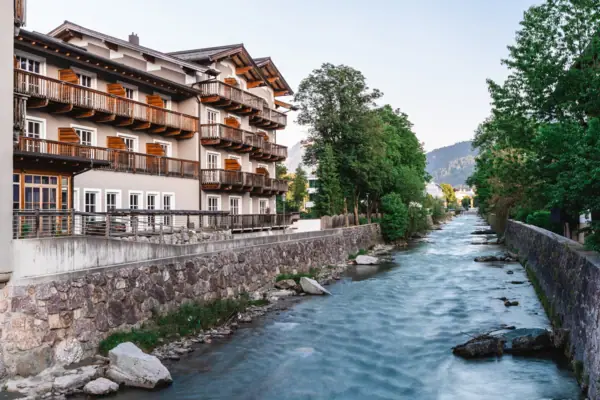 A river with a building and trees in the foreground