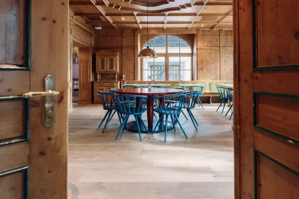 A room with a round table and blue chairs.