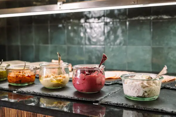 A group of bowls of food on a counter.