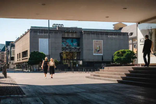 Two women are walking across a square.