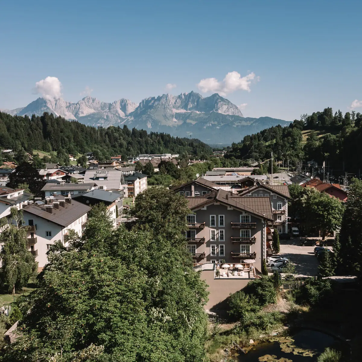 Kitzbühel seen from above, with trees and mountains in the background.