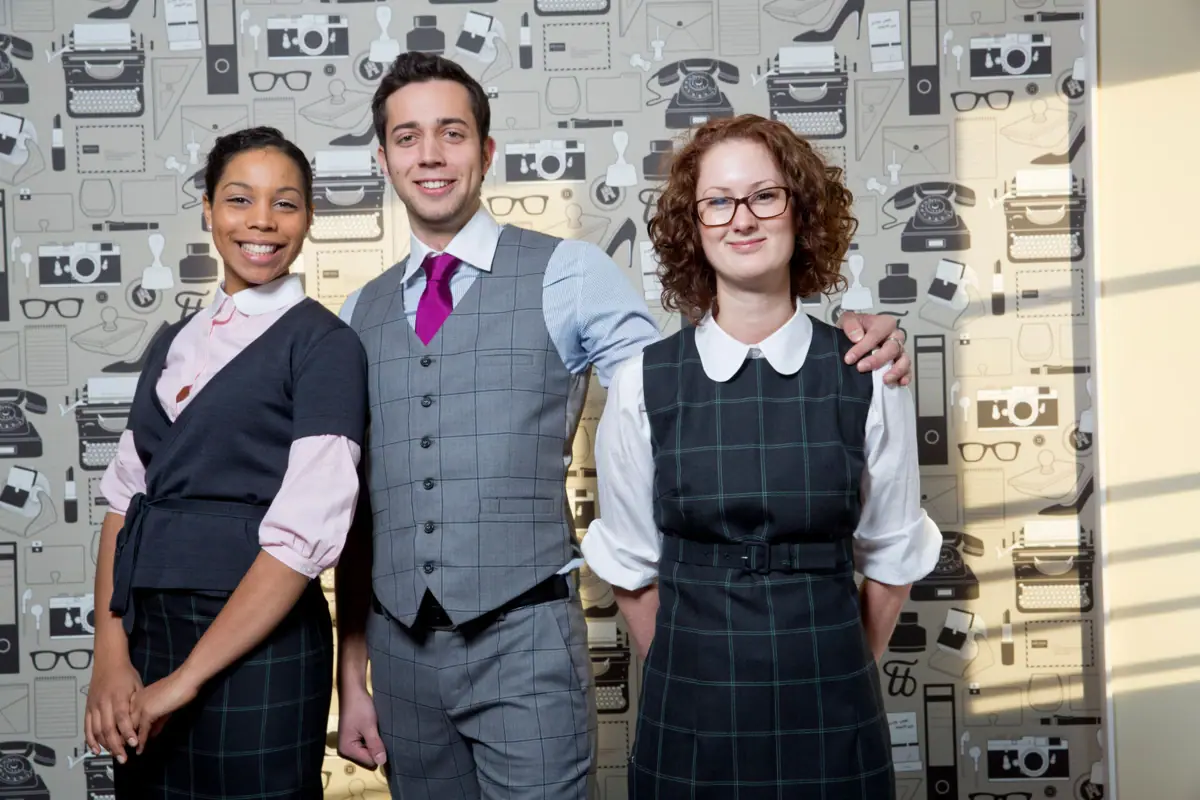 A group of people pose for a photo, smiling and in formal dress.