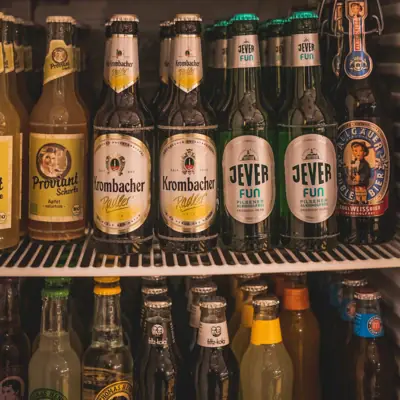 A shelf of a fridge filled with bottles.