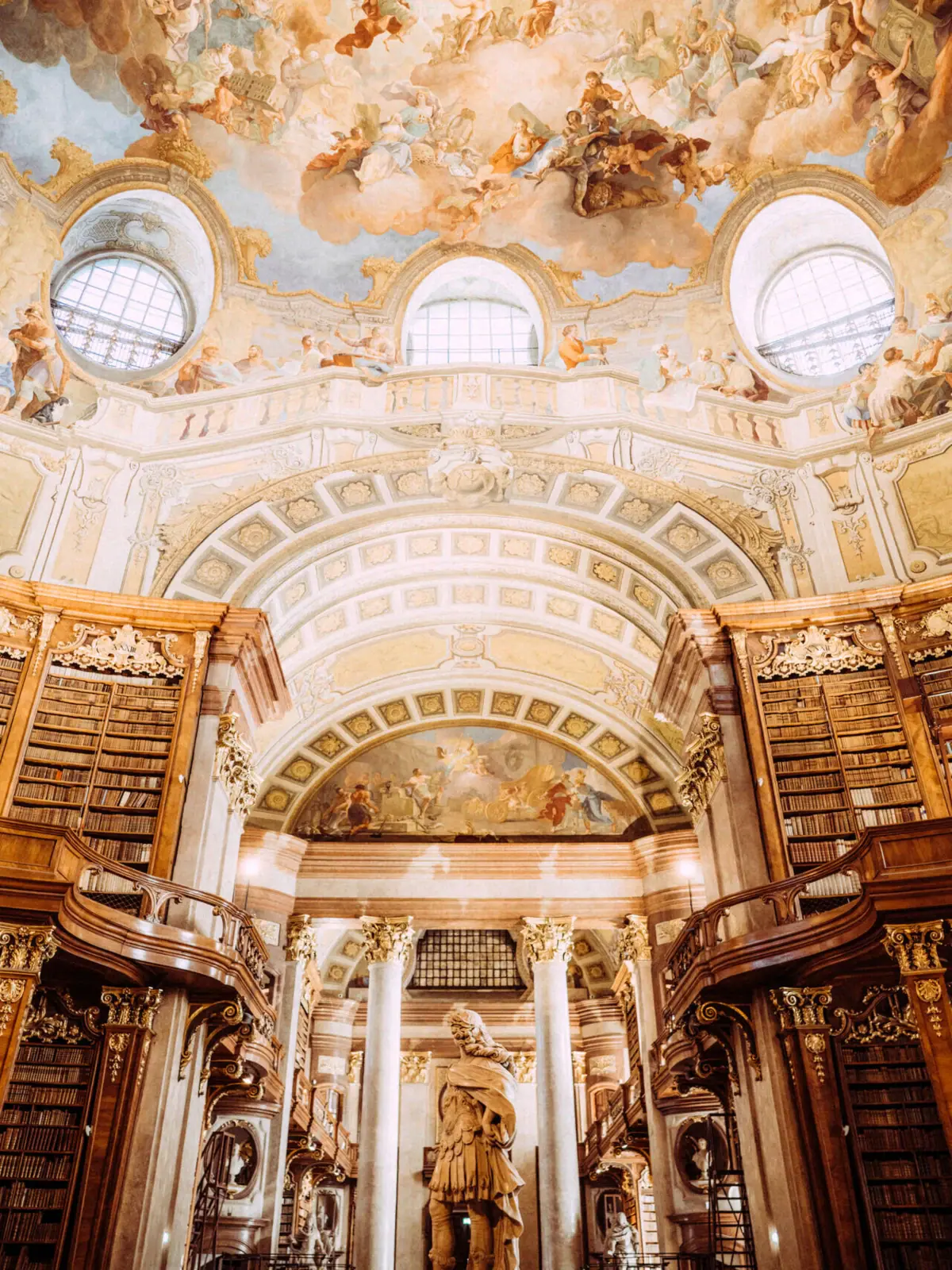 Austrian National Library A large, ornate library with a ceiling fresco.