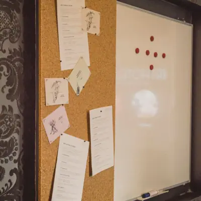 Pinboard with various papers and handwritten notes.